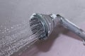 Shower tap is on with water is fall in down. steel colour tap with pink colour background. Royalty Free Stock Photo