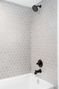 A shower with textured hexagon tiles.