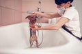 Woman washing cute little dog after shaving in salon Royalty Free Stock Photo