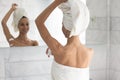 After shower woman apply at armpit area antiperspirant rear view