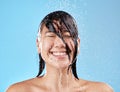 Shower, woman and water with a face cleaning for clean, wash and hygiene on a blue studio background. Bathroom