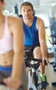 Showing the cycle whos boss. A man and woman exercising in spinning class at the gym. Royalty Free Stock Photo