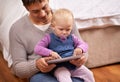 Showing dad how its done. A young father showing his baby girl something on a digital tablet. Royalty Free Stock Photo