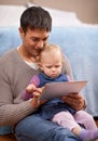 Showing dad how its done. A young father showing his baby girl something on a digital tablet. Royalty Free Stock Photo