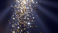 Golden and Silver Confetti Falling in Rays of Light Against a Dark Blue Background Royalty Free Stock Photo