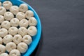 Showing half plate of some small homemade freshly fermented raw bread dough pulp on a black background