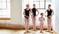 Showing her the way of ballet. a group of young ballerinas teaching a little girl ballet in a dance studio. Royalty Free Stock Photo