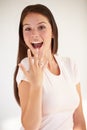 Showing off her engagement ring. Portrait of a beautiful young woman smiling and holding up her hand to show her Royalty Free Stock Photo