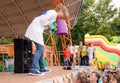 Showing physical and chemical experiments for children. Woman with a special air gun for school experiment on stage