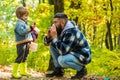 Showing sick Father sneezing at autumn park. Cold flu season, runny nose. Hello Autumn bye Summer. Cute boy with Autumn Royalty Free Stock Photo