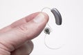 showing small discreet hearing aid between fingers Royalty Free Stock Photo