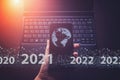 Showing virtual hologram globe, world 2021 on smartphone and keyboard laptop background. Concept for new year 2021. Protecting Royalty Free Stock Photo