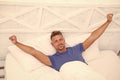 Showing young man stretching in bed. Man stretching in bed. Carefree guy enjoying new day. Wake up. Enjoying Sunday Royalty Free Stock Photo