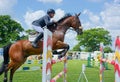 Showjumping. Side view, Horse and rider leap fence at speed