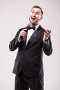 The Showman interviewer with emotions. Young elegant man holding microphone against white background. Royalty Free Stock Photo