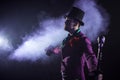 Showman. Young male entertainer, presenter or actor on stage. The guy in the purple camisole and the cylinder. Royalty Free Stock Photo