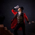 Showman. Young male entertainer, presenter or actor on stage. The guy in the red camisole and the cylinder. Royalty Free Stock Photo