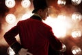 Showman. Young male entertainer, presenter or actor on stage. The guy in the red camisole and the cylinder. Royalty Free Stock Photo