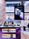 Showroom of modern electronics with new Samsung Galaxy S23 smartphone models and headphones