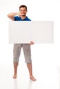 A guy with a beard posing with a white sign. Can be used to place advertising, logo, and other. Dressed in a blue T-shirt and grey