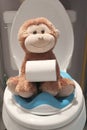 Stuffed monkey sitting on child`s potty seat