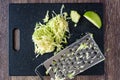 Shredded Granny Smith apple on a black cutting board with a metal grater Royalty Free Stock Photo