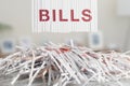 Shredded red BILLS letters above Cut up credit cards on Shredded Bills and Bank Statements Royalty Free Stock Photo