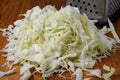 Shredded white cabbage on the table next to the grater