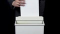 Shredder destroys documents. Businessman in a suit puts a sheet of paper into a paper shredder Royalty Free Stock Photo