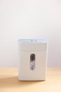 Shredder with paper strips on wooden table Royalty Free Stock Photo