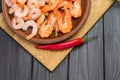 Shrimp in ceramic plate. Chili peppers on cutting board Royalty Free Stock Photo