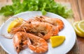 Shrimp grilled bbq seafood on white plate table food - prawns shrimps cooked burnt barbecue with lemon and vegetable salad Royalty Free Stock Photo