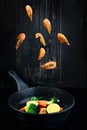 shrimp levitation over a frying pan with vegetables