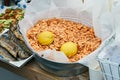 Shrimp in metallic bucket on the wooden table. Boiled pink Prawn Shrimp in a huge bucket packed in white paper with two Royalty Free Stock Photo