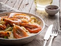 Shrimp, pasta tagliatelle, green peas, dill. White plate on old rustic wooden table, side view Royalty Free Stock Photo