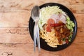 Shrimp Paste Fried Rice with shallot, sweet pork, fried egg, vegetable, and spicy chili on the black dish, and spoon, fork, Royalty Free Stock Photo