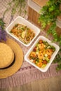 Shrimp salad and Asian pad thai. composition with natural decor. concept food delivery. picnic outdoors summer spring time.