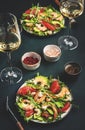 Shrimp salad with avocado, grapefruit, arugula and cashews with dressing, served with white wine in glasses. Gourmet lunch. Green