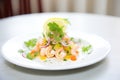 shrimp salad on white plate, lemon wedge, parsley garnish