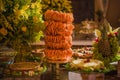 Shrimp tower with table decorated with fruits and cold cakes.