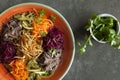 Shrimp vegetable salad in batter on a dark wooden table, oriental and asian cuisines, gourmet asian salad in a square dish, orient