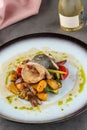 Shrimp wrapped in sea bass on various vegetables on a porcelain plate Royalty Free Stock Photo