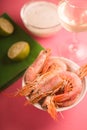 Shrimps in a ceramic bowl, a glass of white wine and a sauce partial blur Royalty Free Stock Photo