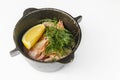 Shrimps with dill and slice of lemon served in a small black pot over white background. Royalty Free Stock Photo