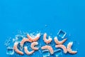 Shrimps - peeled, with ice - on blue table frame copy space