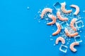 Shrimps - peeled, with ice - on blue table frame copy space