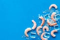 Shrimps - peeled, with ice - on blue table frame copy space