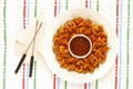 Shrimps with pepper sauce over white plate beside forks