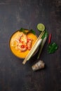 Shrimps Tom Yam Kung in grey bowl with thai spices on autentic tray top view, wooden background