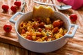 Shrimps in white baking dish on wooden background. Baked with cherry tomatoes and feta cheese Royalty Free Stock Photo